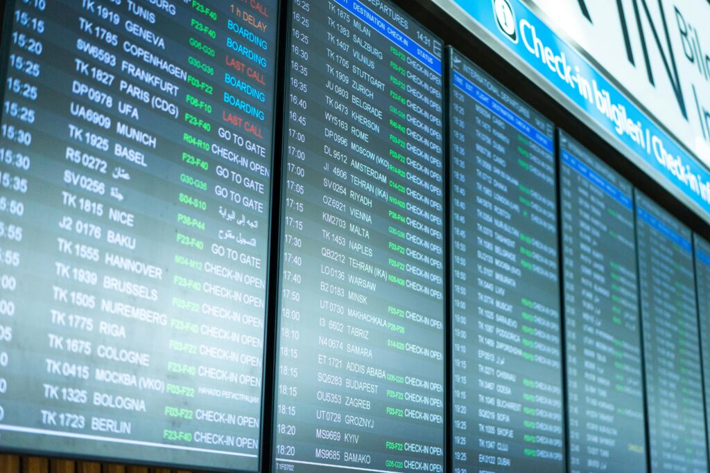 Airport departure boards listing flight times, gates and check-in status